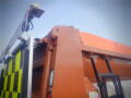 A 2016 International WorkStar 7500 truck with a bright orange dump bed and reflective yellow-green markings on the side