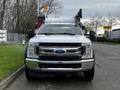 Front view of a white 2018 Ford F-550 with a prominent grille and dual headlights designed for heavy-duty work