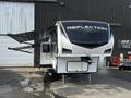 A 2021 Grand Design Recreational 311BHS travel trailer featuring a sleek, modern design with a large front window and extendable awnings on both sides