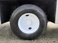 A close-up of a black tire mounted on a white rim belonging to a 2010 International 4300 vehicle
