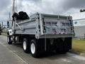 A 2017 International WorkStar 7600 truck with a silver dump bed and large rear wheels parked on a driveway