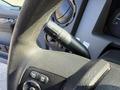 Close-up of a 2015 Ford F-550 steering wheel showing the windshield wiper control stalk and various buttons for vehicle settings