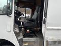 A 2012 Workhorse W62 truck cab featuring a black driver's seat, steering wheel, and dashboard with controls and a textured floor surface