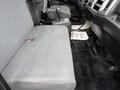 The interior of a 2017 Hino 338 featuring a gray bench seat with a seat belt and a dark floor mat with thank you written on it
