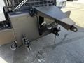 A close-up of the front of a 2005 Volvo VND 122 showing a robust black mounting plate with hooks and chains attached