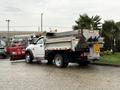 A 2012 Dodge Ram 5500 equipped with a snow plow and a dump bed positioned on a wet surface