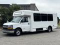 A 2020 Chevrolet Express in white with a boxy shape and large windows designed for passenger transport