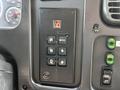 A control panel from a 2004 Freightliner M2 featuring buttons for gear selection labeled R N D and mode settings along with various gauges and switches