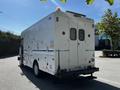 A 2009 Morgan Olson Workhorse box truck with a white exterior features multiple compartments and a roof-mounted light bar