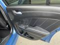 A close-up of the interior door panel of a 2022 Dodge Charger featuring black leather with stitching and a silver door handle