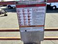 A safety sign on a metal frame with various hazard symbols and instructions related to operating the 2010 SkyJack SJ lift