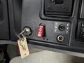 Close-up of the dashboard of a 2013 International 3000 showing a key ignition switch a red shutdown button and other control buttons