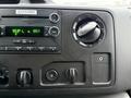 Interior dashboard of a 2013 Ford E-350 showing the radio controls display and knobs for temperature and air circulation settings