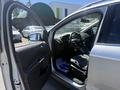 A 2014 Ford Escape with the driver's side door open showing the interior including the steering wheel and front seats