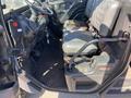 The interior of a 2018 Kubota RTV-X 1100 C featuring two bucket seats with armrests a steering wheel and various controls on the dashboard