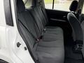 Interior view of a 2012 Nissan Versa showing the backseat with black fabric upholstery and seatbelts
