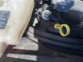 A close-up view of a 2020 Chevrolet Express engine showing the yellow dipstick and nearby components including a coolant reservoir and engine oil cap