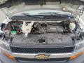 A 2020 Chevrolet Express with its hood open showcasing the engine compartment including various mechanical components and fluids