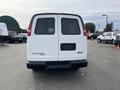 A white 2012 GMC Savana van viewed from the rear with a blank license plate and red taillights