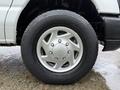 Close-up of a silver alloy wheel on a 2013 Ford E-350 featuring a five-spoke design and mounted on a black tire with visible tread pattern
