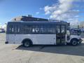 A 2018 Chevrolet Express bus with a white exterior and large windows parked on a paved area