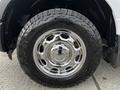 Close-up of a chrome wheel on a 2016 Ford F-150 featuring a rugged tire with raised tread patterns