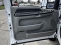 2007 Ford F-550 truck door interior featuring a gray panel with controls for windows and locks along with a textured handle and speaker grille