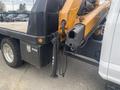A 2017 Ford F-550 with a flatbed and hydraulic boom mechanism visible on the rear of the vehicle