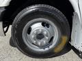 A close-up of a silver wheel and tire from a 2013 Chevrolet Express featuring a six-bolt pattern and Bridgestone tire brand markings