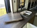 A 2017 Ford Transit with a wooden countertop featuring a sink and a sleek black faucet