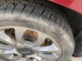 Close-up of a silver alloy wheel with a dark center cap featuring the Fiat logo and a textured tire showing tread patterns and minor wear