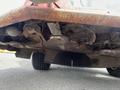 A 2012 Toro Groundsmaster 5910 showing the underside with visible blades and debris accumulated around the cutting area