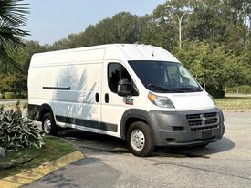 2017 RAM Promaster cargo van with a white exterior and gray accents parked on a street