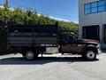 A 2015 RAM 5500 with a dark cargo bed and silver accents is parked, showcasing its robust build and dual rear wheels