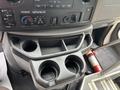 Interior console of a 2014 Ford E-350 with storage compartments and two cup holders visible