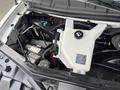 Engine compartment of a 2022 GMC Savana showing the coolant reservoir battery and various cables and components