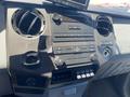 The interior dashboard of a 2015 Ford F-450 SD featuring controls for audio and climate settings along with multiple buttons for vehicle functions