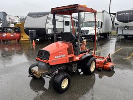 A 2012 Kubota F3680, a compact tractor with a red body, featuring a canopy and a front-mounted mower deck, is parked on a wet surface
