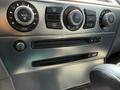 The dashboard controls of a 2004 BMW 6-Series featuring climate control knobs and CD and DVD slots