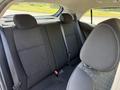 The interior of a 2018 Kia Rio5 showing the back seat area with black fabric upholstery and seatbelts