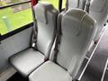Two gray seats with safety belts in a bus interior designed for passenger use