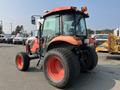 A 2014 Kubota tractor with an orange and black exterior featuring a large cabin and oversized rear tires