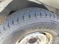 A close-up view of a Bridgestone tire with a rugged tread pattern mounted on a wheel from a 2007 Chevrolet Express
