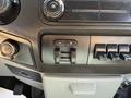 Close-up of the dashboard controls of a 2014 Ford F-250 SD featuring various knobs buttons and switches for audio and auxiliary functions