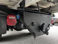 The underside of a 2011 Ford F-550 showing its rear chassis and tow hitch with a painted black surface and red taillights visible