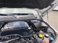 Engine compartment of a 2006 Land Rover LR3 featuring a black engine cover with various fluid reservoirs and caps visible