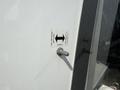 A close-up of a door handle mechanism on a 2020 Chevrolet Express with a directional sign indicating open and close operations