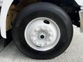 Close-up view of a white wheel with a black tire on a 2006 Hino 268 vehicle showing the lug nuts and center hub