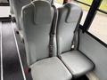 Two grey seats with seatbelts designed for safety in a bus setting