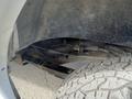 A close-up view of the undercarriage and wheel well of a 2022 GMC Savana showcasing suspension components and tire tread details